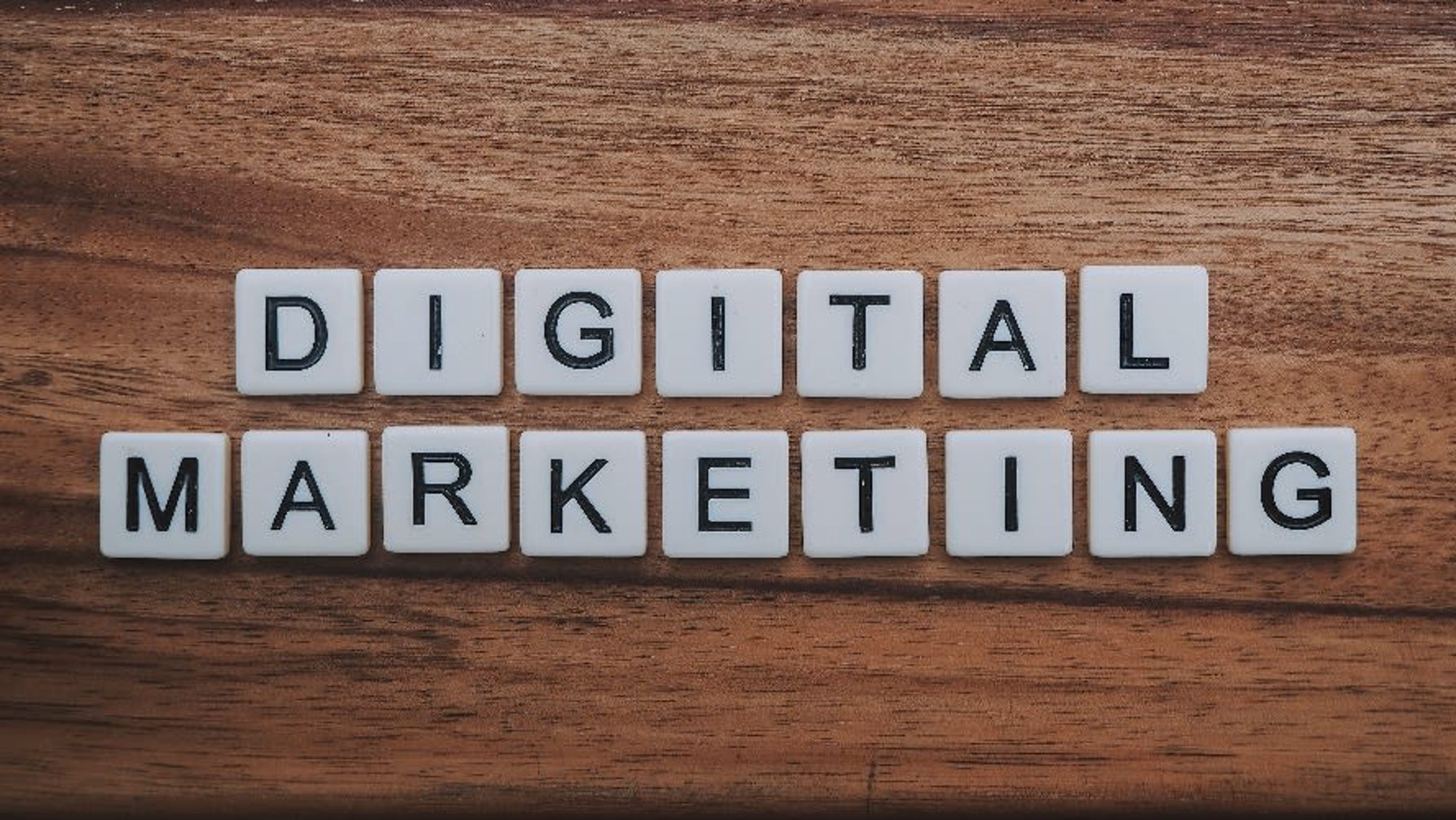 scrabble pieces on wooden table spelling out "digital marketing"