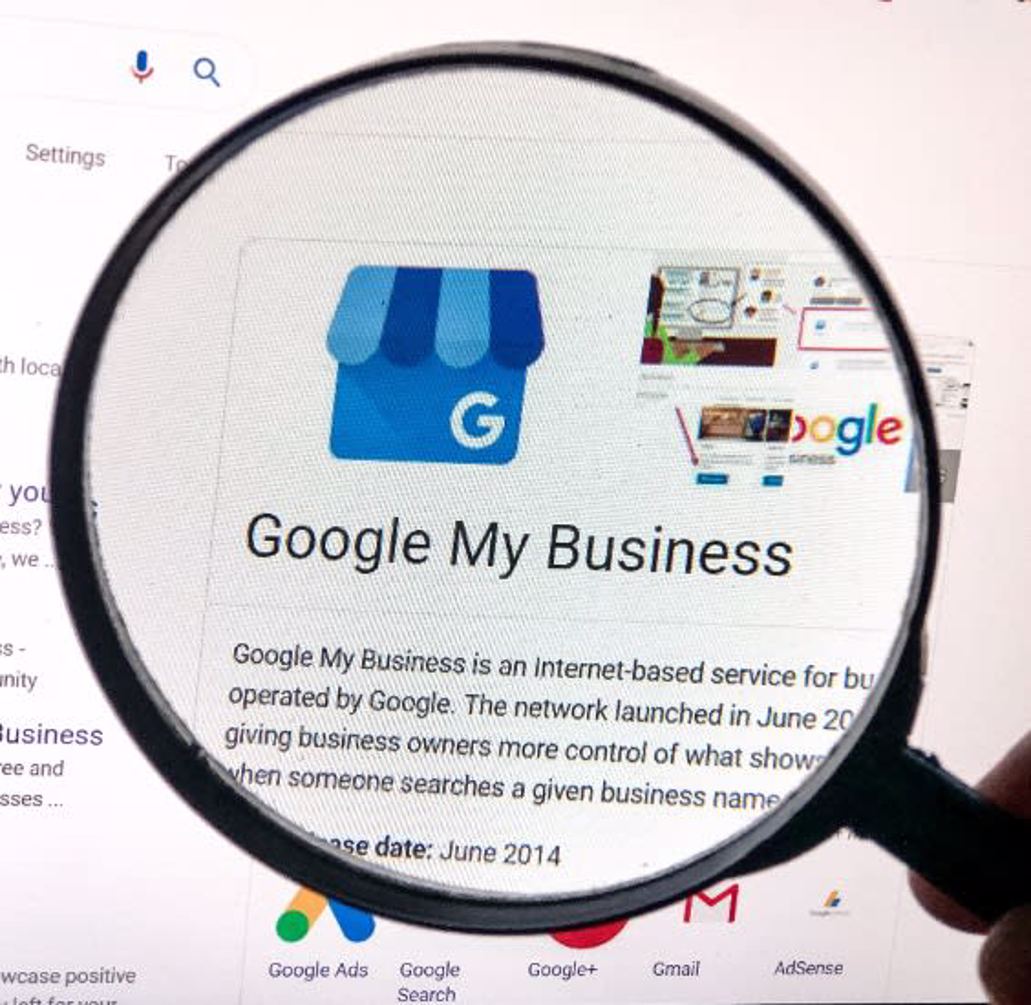 magnifying glass over computer screen highlighting Google My Business