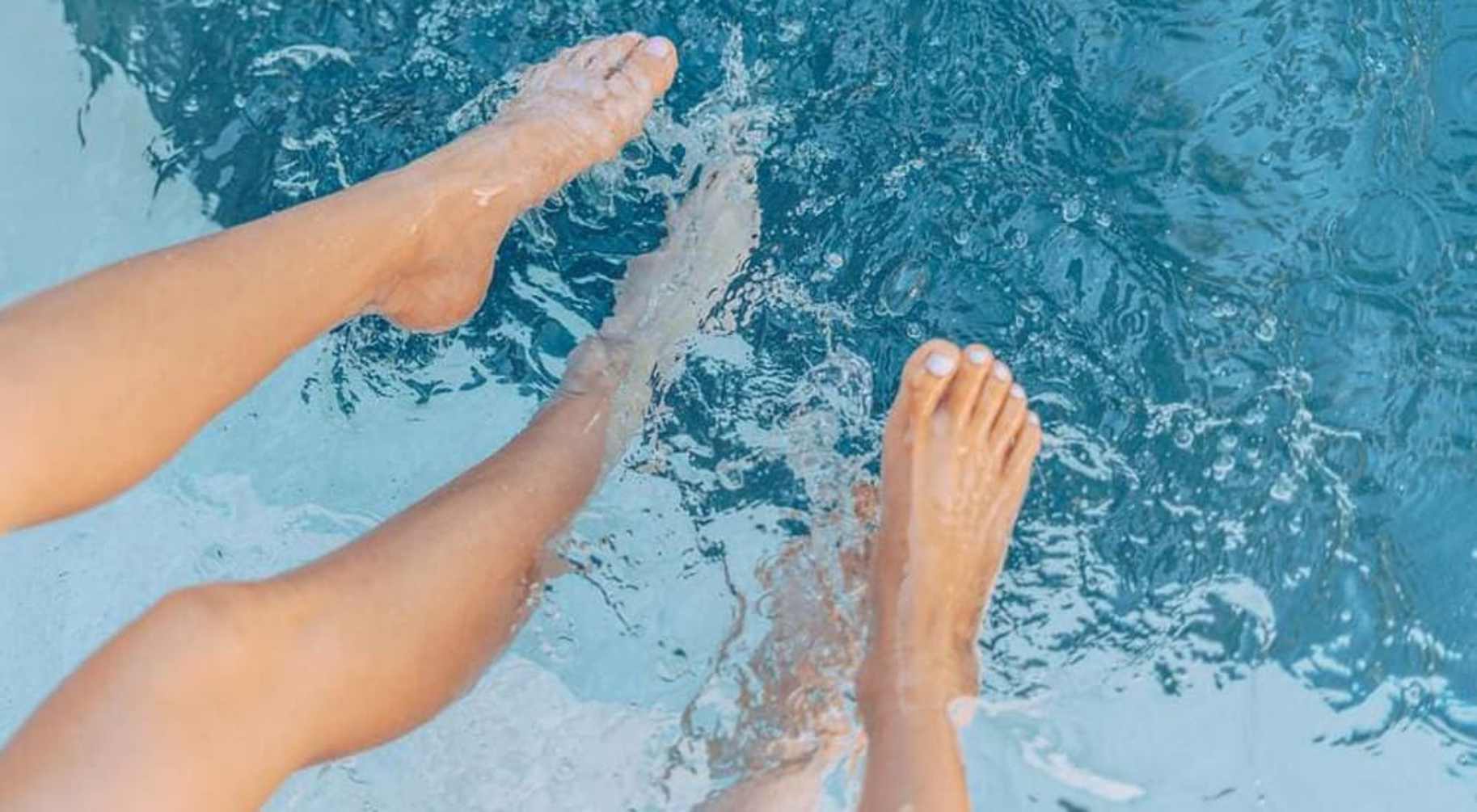 People's feet in a pool